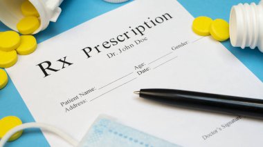 Tablet hap veya uyuşturucu şişe ve sarı tabletler ya da ilaç ve tıbbi maskesi ile mavi arka plan için reçete