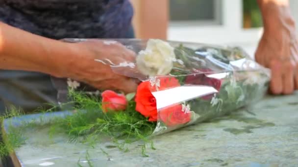 Γυναίκα χέρια Ανθοπωλεία (Ανθοπωλείο) καθιστώντας την ανθοδέσμη με τριαντάφυλλα στο τραπέζι για Ανθοπωλείο εξωτερική — Αρχείο Βίντεο