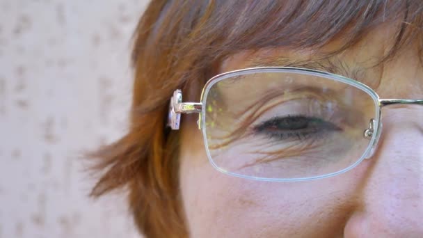 老妇人面孔以绿色眼睛和褐色头发与玻璃 — 图库视频影像