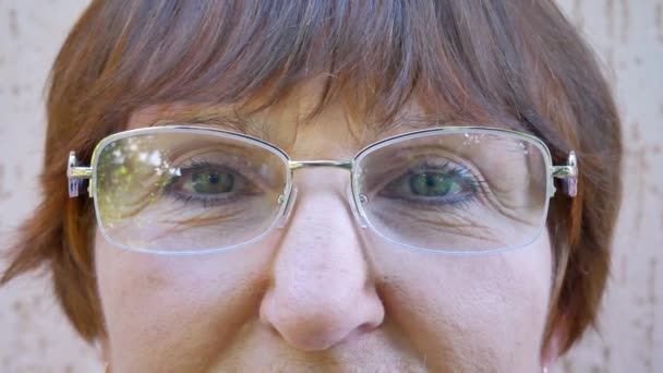 Ögonen på den gamla kvinnan med glasögon tittar — Stockvideo