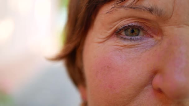 Gamla kvinnan ansikte med gröna ögon och brunt hår — Stockvideo