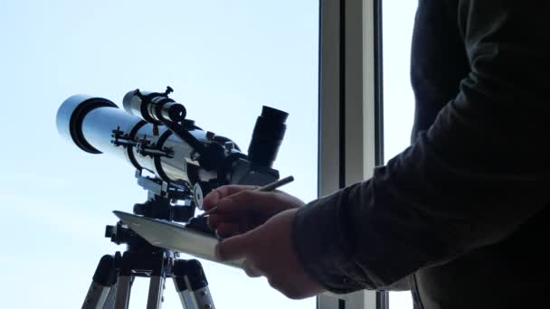 Человек с астрономическим телескопом смотрит на звезды — стоковое видео