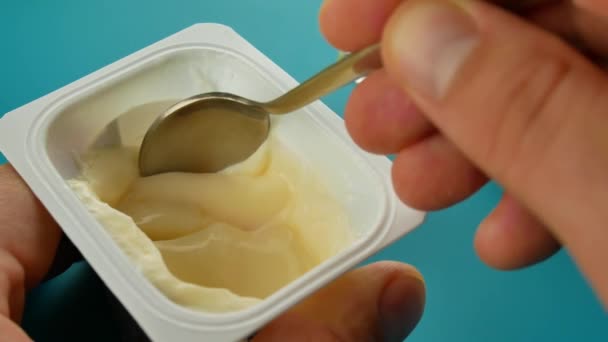 Plastic beker met heerlijke lekkere yoghurt op tafel op groene achtergrond — Stockvideo