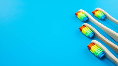 Mavi arka plan üzerinde gökkuşağı bambu ahşap diş fırçaları