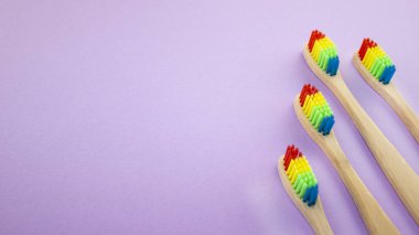 Gökkuşağı ahşap diş fırçaları menekşe veya mor zemin üzerine. Irkçılık, sosyal dışlanma, depresyon ya da yalnızlık, sosyal sorunlar ya da yasa dışı göç kavramı