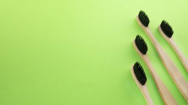 Yeşil bir arka plan üzerinde siyah ahşap diş fırçaları