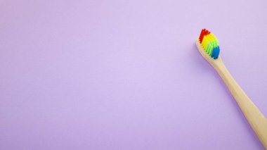 Gökkuşağı menekşe veya mor zemin üzerine ahşap toothbrushe. Irkçılık, sosyal dışlanma, depresyon ya da yalnızlık, sosyal sorunlar ya da yasa dışı göç kavramı