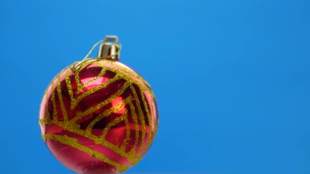 Dekorierte rote Weihnachtskugeln auf blauem Hintergrund — Stockvideo