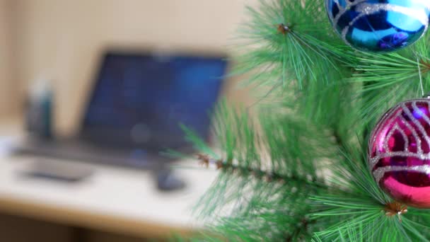 Businessman hanging gold Christmas ball on a Christmas tree — Stock Video