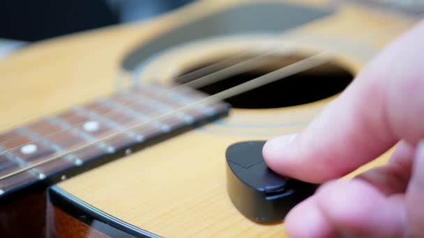 Guitarist takes a mediator or plectrum from acoustic guitar — Stock Video