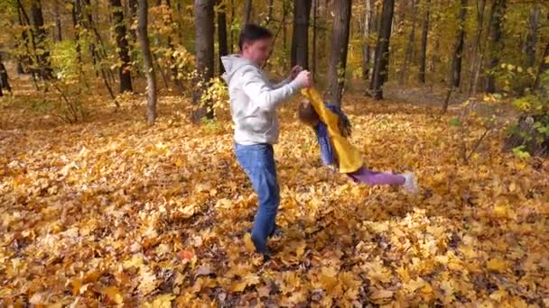 Père heureux tourne son petit enfant heureux dans ses bras au parc 
