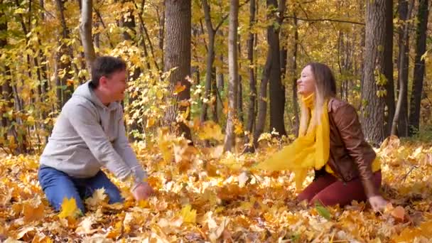 Stylish young happy smiling couple play on a sunny day in autumn park — Stock Video