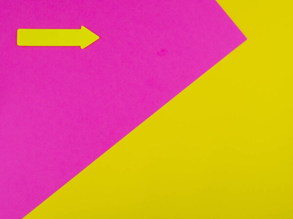 Yellow and pink background with yellow arrow and copyspace for text