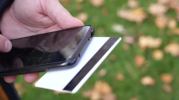Επανδρώνει χέρια κρατώντας μια πιστωτική κάρτα και χρησιμοποιώντας έξυπνο τηλέφωνο για online αγορές — Αρχείο Βίντεο