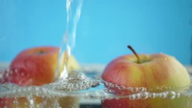 Şeffaf kabarcıklar ekmek kırıntısı ile su altında kırmızı sarı elma