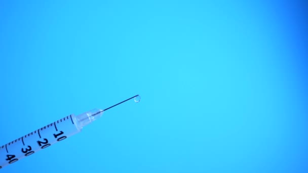 Spruta med droppar närbild isolerad på blå bakgrund — Stockvideo