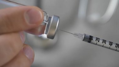 Sağlık doktor aşı bir şırınga çevirir.