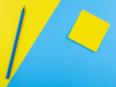 Ahşap sarı kalem mavi doku kağıt üzerinde izole ve sarı kare ile birleştirir. Üstten görünüm kavramı kopya boşluk ile minimalist şablonu