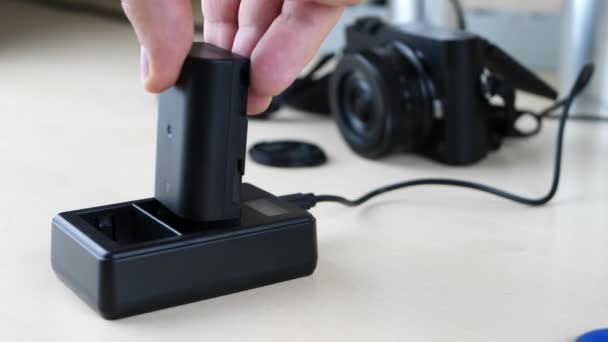 Camera lader en batterij op houten tafel — Stockvideo