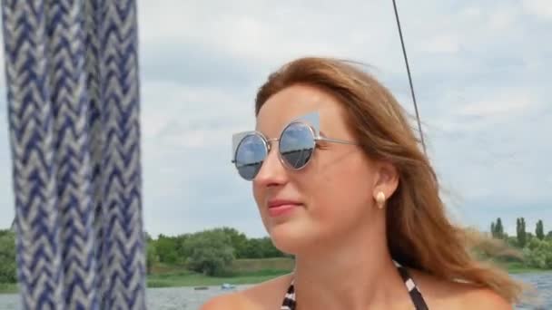 Bella ragazza con i capelli castani chiaro si trova su yacht e prendere il sole — Video Stock