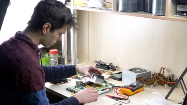 Joven trabajando con ventilador de CPU en placa base de PC verde — Vídeo de stock