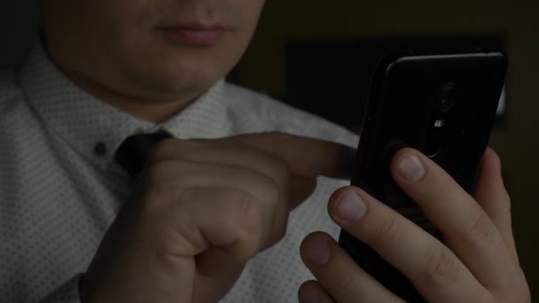 Менеджер или бизнесмен в белой рубашке с галстуком на черном смартфоне — стоковое видео