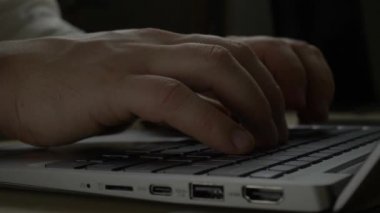 Adam üstünde laptop klavye yazarak metin gece karanlık eller.