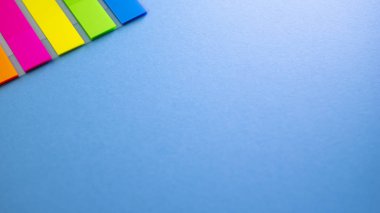 Mavi arka plan üzerinde renkli yer imleri. Yukarıdan kopya alanı ile göster