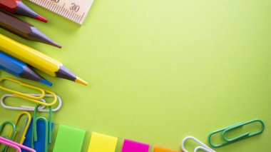 İleti örneği arka planı yeşil üzerinde. Kalem, kurşun kalem, makas, ataç, renkli itme pins ve masanın üzerinde. Yukarıdan kopya alanı ile göster