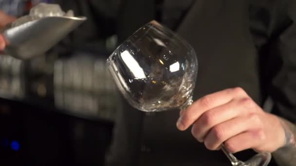 Barmann gießt Eiswürfel in Cocktailglas — Stockvideo