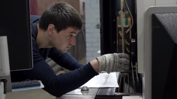 Ingeniero ajusta la máquina para cortar placas metálicas — Vídeo de stock