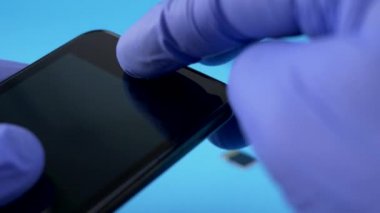 Teknisyen alt siyah smartphone tutan mavi eldiven