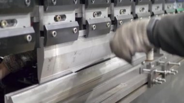 İşçi metal plaka endüstriyel makine üzerinde eğilir.