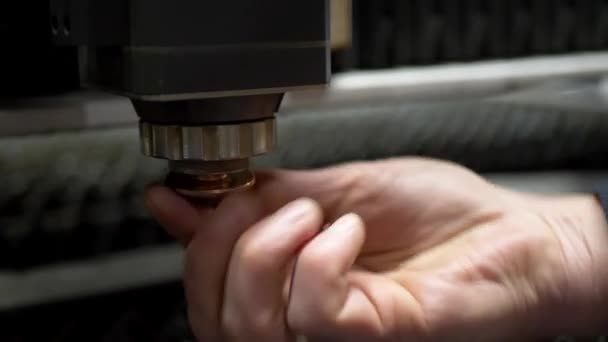 La main des ingénieurs ajuste la machine laser CNC pour couper le métal