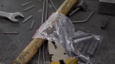 Çalışma alanı ile çekiç, pense, İngiliz anahtarı ve metal parçalar