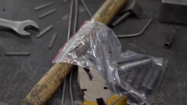 Lugar de trabajo con martillo, alicates, llave inglesa y piezas metálicas — Vídeo de stock