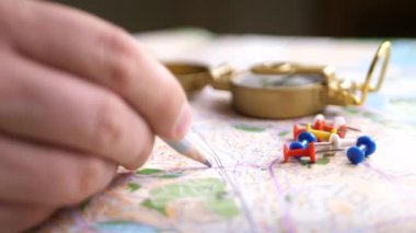 Mens pusula ve çok renkli iğne ile planlama seyahat parmak. Gezi yolu hedef harita kavramı