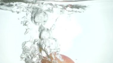 Şeffaf kabarcıklar ekmek kırıntısı ile su altında kırmızı sarı elma