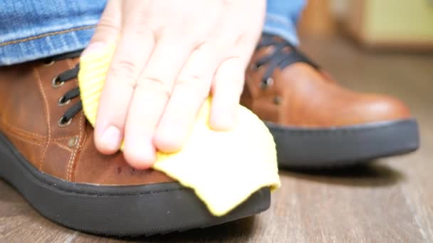 Zapatos de cuero marrón desempolvado a mano con un trapo amarillo — Vídeos de Stock