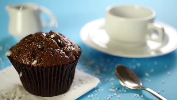 干椰子片落在巧克力蛋糕或甜点上的蓝色桌子上 一杯咖啡 — 图库视频影像