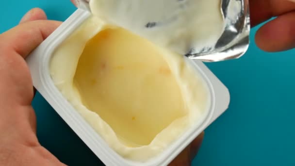 Copa de plástico con delicioso yogur sabroso en la mesa sobre fondo verde — Vídeo de stock
