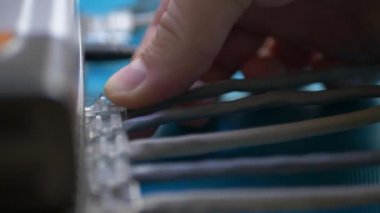 Adam Ethernet kablosu yönlendiriciye takılan.