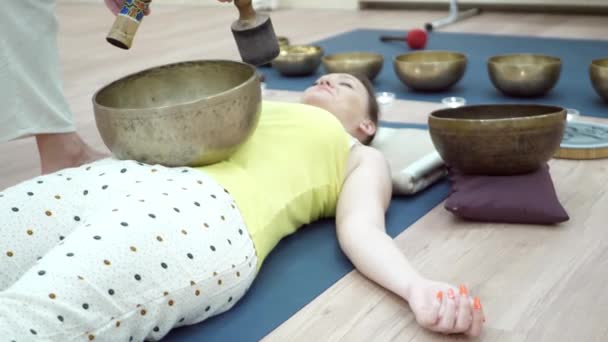 Joven mujer deportista practicando yoga con instructor en gimnasio — Vídeos de Stock