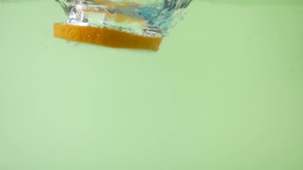 Färsk apelsin skivad falla i vatten med stänk — Stockvideo