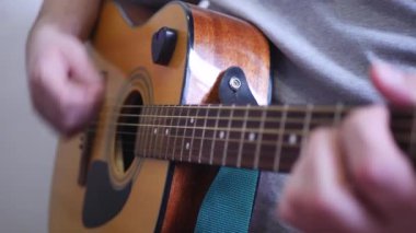 Adam akustik ahşap 6 telli gitar çalmak