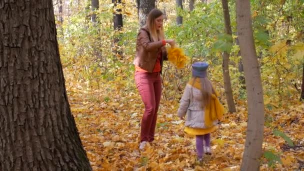 Mère tricote couronne de feuilles jaunes avec l'enfant 