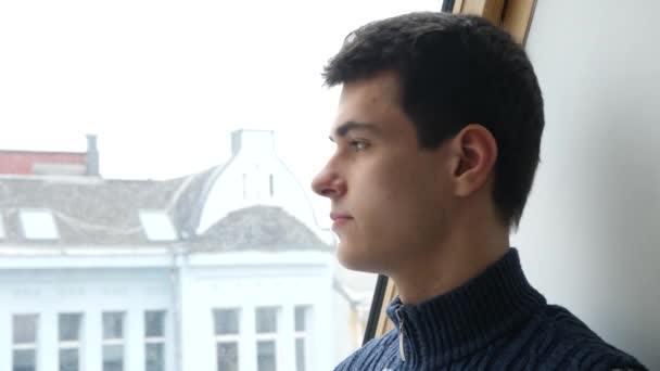 Студент смотрит в окно — стоковое видео