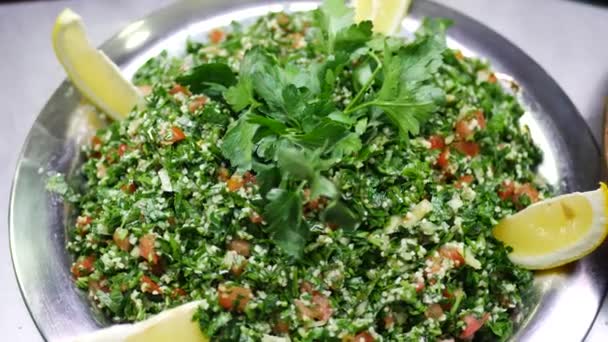 Салат из просо с листьями петрушки, зеленый укроп, ломтики помидоров и лимона — стоковое видео
