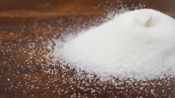 Разовый сахар падает на гранулированный сахар — стоковое видео