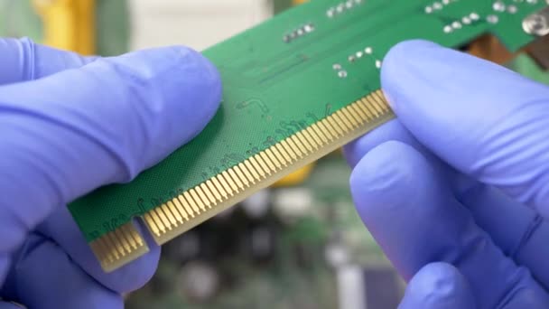 Hand in blauwe handschoenen houdt PCI Express-kaart voor computer — Stockvideo